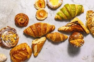 Frisch gebackene Buttercroissants der Pâtisserie Elysée, angerichtet auf einem Tisch im Café, Teil des aktuellen Monatsangebots 2026.